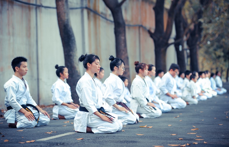 Two rows of karate students sitting in kneeling pose